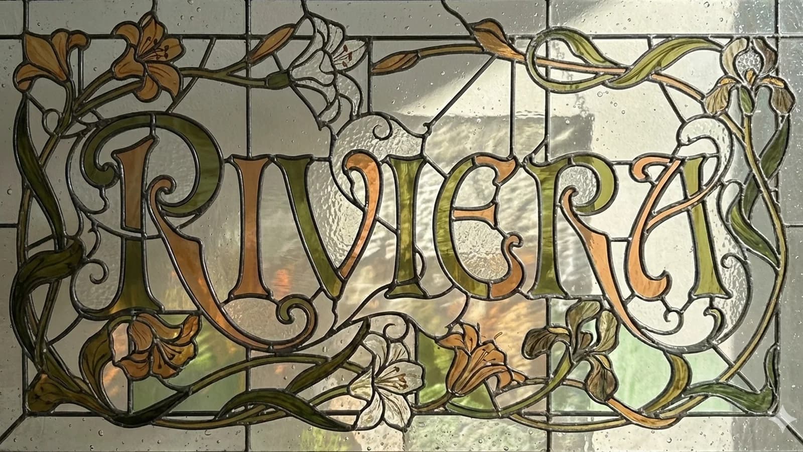 An Art Nouveau stained-glass panel with the word RIVERA formed in ornate lettering